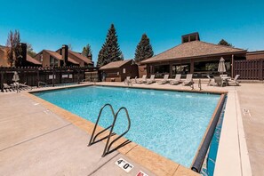 A swimming pool with a lifeguard stand, lounge chairs, and a covered area with a roof. - Three Kings 1 at Park City Mountain (Park City)