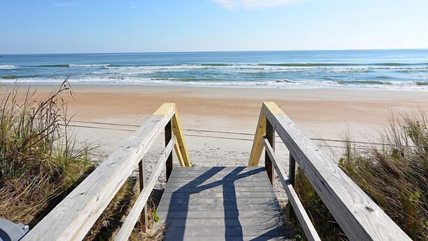 A wooden boardwalk leading to a sandy beach with ocean waves in the background. - Surf Condos 222 - Community Pool & Beach Bliss! (Surf City)