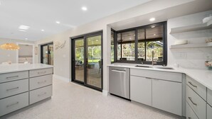 Una cucina moderna con lavastoviglie, un'ampia finestra e vista sull'esterno.
