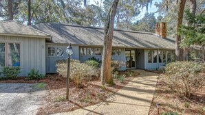 A single-story house with a porch, a chimney, and a pathway leading to the entrance. - 1 Deer Run: Newly Listed & Furnished Home, Dog Friendly, 4 BR, Bikes (Hilton Head Island)