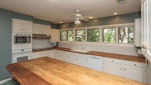A kitchen with white cabinets, a wooden countertop, a microwave, a stove, and a ceiling fan. - 1 Deer Run: Newly Listed & Furnished Home, Dog Friendly, 4 BR, Bikes (Hilton Head Island)