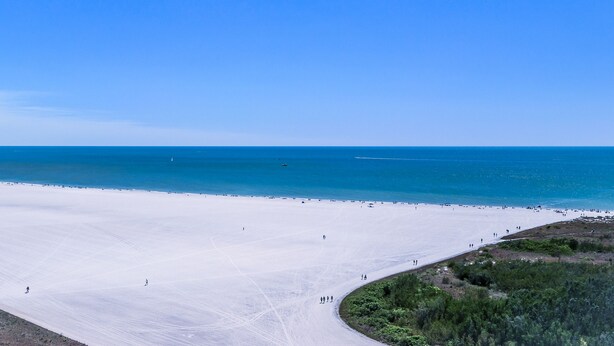 A wide beach with a clear sky and calm sea. - Great Beach Views, Direct Access, Pickleball, New Kitchen & Heated Pool! Tower 3 (Marco Island)