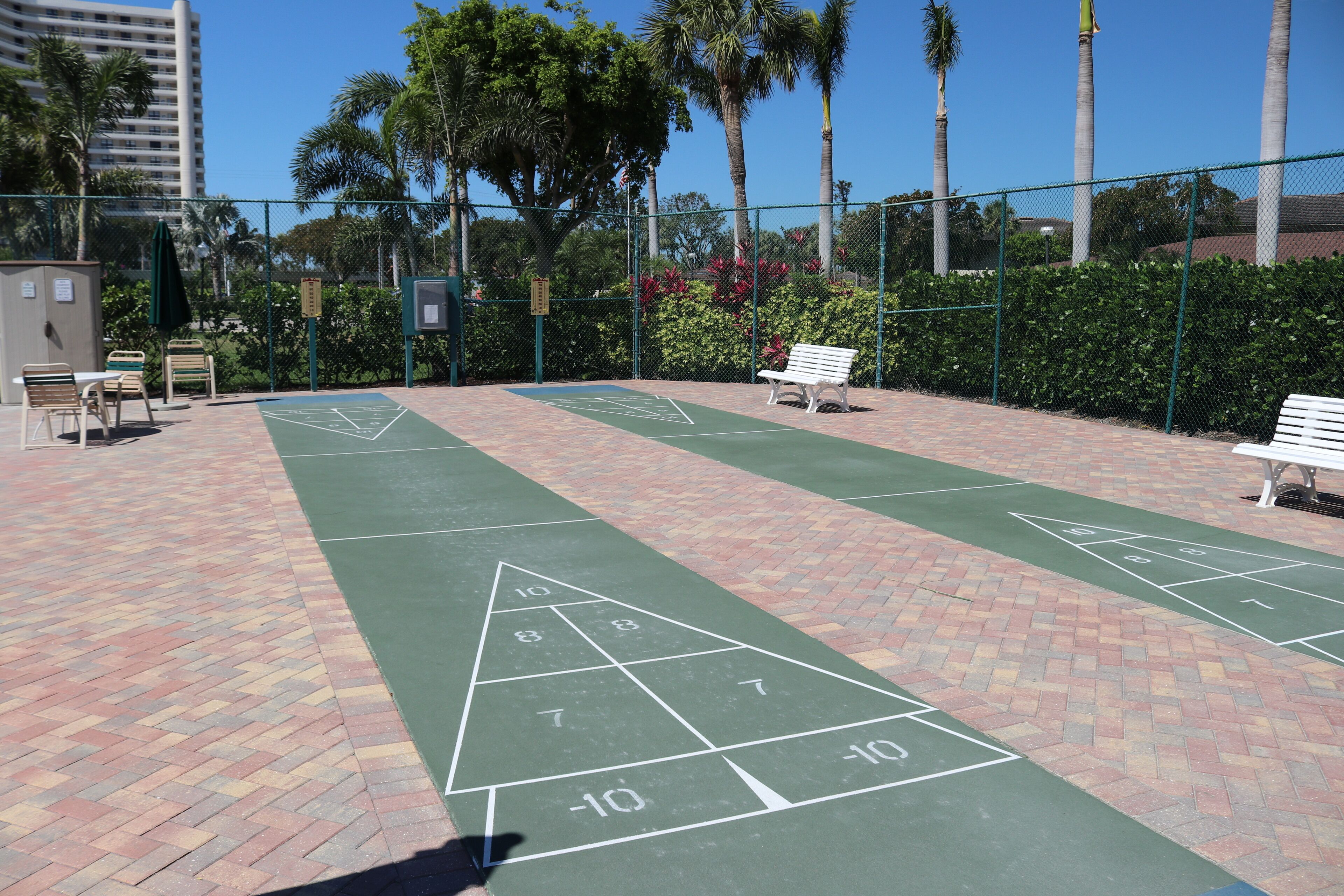 Un terrain de jeu de shuffleboard doté d’une surface verte, marquée de chiffres et de triangles.