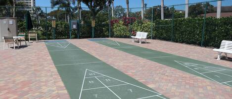 Un terrain de jeu de shuffleboard doté d’une surface verte, marquée de chiffres et de triangles.
