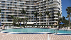 A hotel with a large pool surrounded by lounge chairs and palm trees. - Great Beach Views, Direct Access, Pickleball, New Kitchen & Heated Pool! Tower 3 (Marco Island)