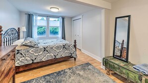A bedroom with a bed, wooden dresser, and a mirror. - Downtown Grand Haven Apt < 1 Mi to Lake Michigan (Grand Haven)