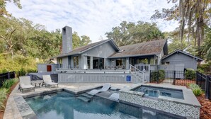 A house with a swimming pool, a covered patio, and a fenced yard.