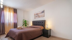 En pænt redt seng med et brunt sengetæppe, en sengegavl og et natbord med en lampe.