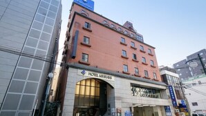 A hotel with a red facade, a large arched entrance, and a sign reading "HOTEL MYSTICUS". - H​OTEL MYSTAYS Kagoshima Tenmonkan Annex (Kagoshima)