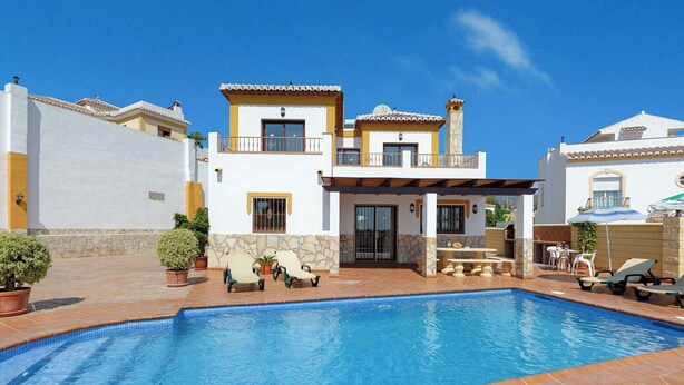 A poolside area with a swimming pool, outdoor seating, and a two-story building with balconies. - Villa Jara - Three Bedroom Villa, Sleeps 6 (Nerja)