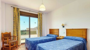 A hotel room with two beds, a wooden chair, a table, and a window with curtains. - Villa Jara - Three Bedroom Villa, Sleeps 6 (Nerja)