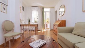 A living room with a wooden coffee table, a beige sofa, a dining table with chairs, and a wooden cabinet. - Rome, near Piazza di Spagna, cozy apartment for 6  (Rome)