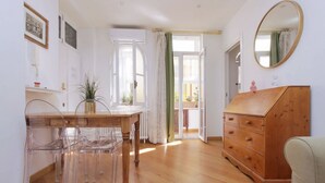 A room with a wooden dresser, a mirror, a table with chairs, and a view through an open door. - Rome, near Piazza di Spagna, cozy apartment for 6  (Rome)