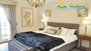 Una camera da letto con un letto grande, due comodini, un lampadario e opere d'arte alle pareti.