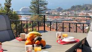 Un balcone con una colazione allestita, con frutta, uova e succo d'arancia.