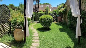 A garden with a pergola, a stone pathway, and a potted plant. - Villa with garden surrounded by greenery a stone's throw from the sea (Santa Margherita di Pula)