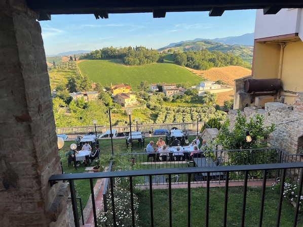 Terraço com área de estar ao ar livre, vista para vinhedos e colinas.