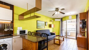 Un espacio habitable compacto con cocina, comedor y zona de estar.