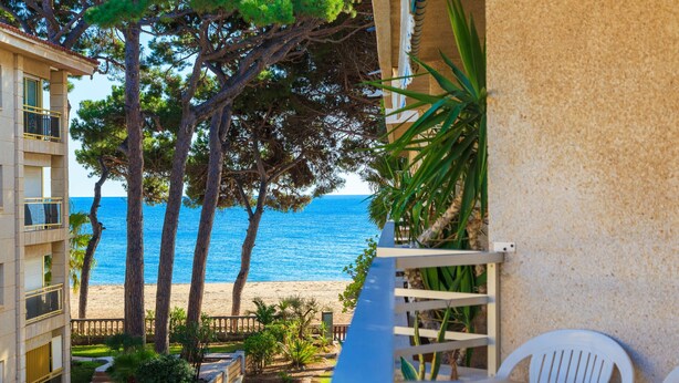 Un balcón con vista a la playa y al océano.