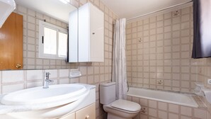 Un baño con lavamanos, inodoro y bañera.