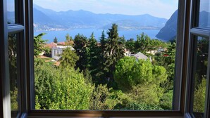 Vista a través de una ventana de un paisaje montañoso con un lago y casas.