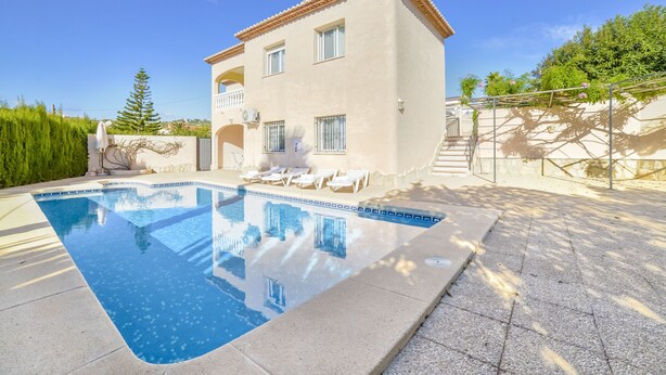 Ein zweistöckiges Haus mit Swimmingpool, Sitzgelegenheit im Freien und einem Garten.