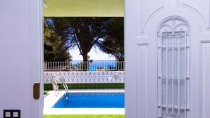 A pool with a metal ladder, a tiled wall, and a view of the sea. - Private swimming pool and jacuzzi in Cap Salou (Salou)