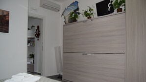 A hotel room with a bed, a wardrobe, a mirror, and a door leading to a bathroom. - Detached apartment (Salerno)