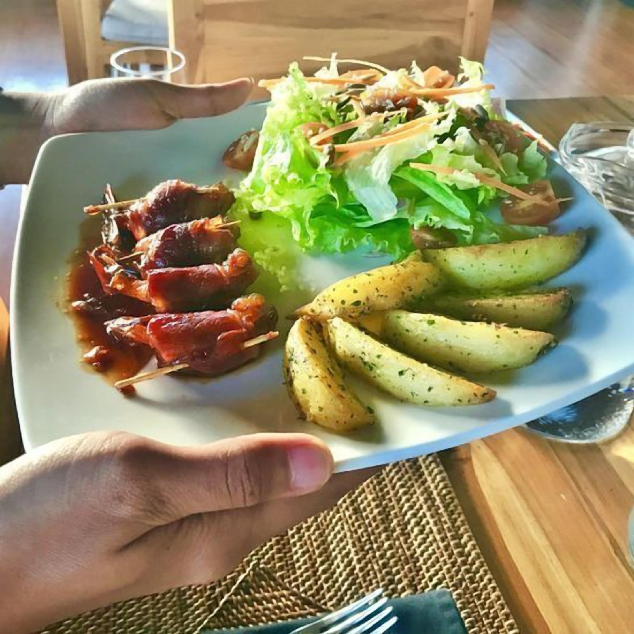 A plate with grilled meat, roasted potatoes, and a salad.