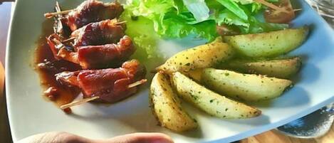 A plate with grilled meat, roasted potatoes, and a salad.
