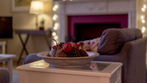 A cozy living room with a decorative bowl on a nightstand, a fireplace with lights, and a comfortable couch. - 4* House / Beautiful Sea Views / Woodland Walks / Dog Friendly (Stranraer)