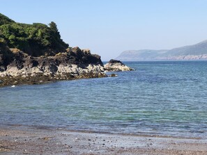 A coastal landscape with rocky shores and clear blue water.