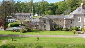 A large stone building with multiple windows and a well-maintained lawn in front. - 4* House / Beautiful Sea Views / Woodland Walks / Dog Friendly (Stranraer)