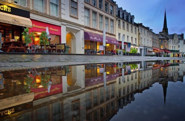 A European street with a reflective water surface, storefronts, and a church spire. - Stay somewhere unusual , Peaceful central location, sleeps 4, Pets Welcome. (Perth)