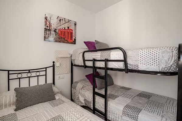 Habitación con literas y un cuadro de un paisaje urbano en la pared.