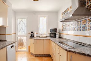 Eine kleine Küche mit eingebauter Mikrowelle, einem Toaster und einem Geschirrspüler.