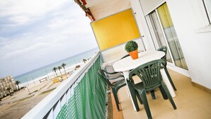 A balcony with a table and chairs, overlooking a beach. - PINEDA 3 with sea views, beach at 100m (La Pineda)