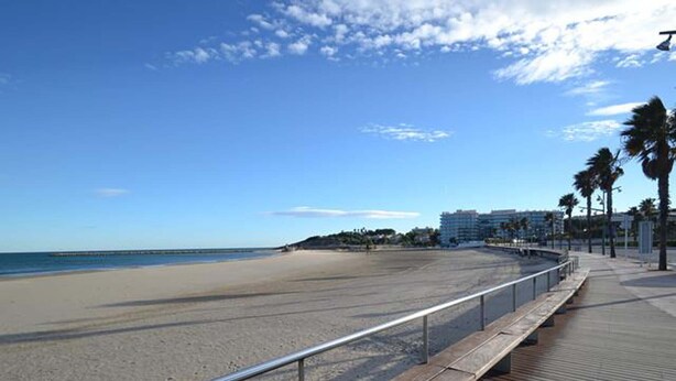 A beach with a wooden boardwalk, palm trees, and a clear sky. - PINEDA 3 with sea views, beach at 100m (La Pineda)
