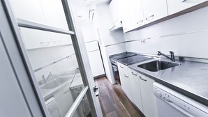 A modern kitchen with white cabinetry, a stainless steel sink, and a built-in dishwasher. - PINEDA 3 with sea views, beach at 100m (La Pineda)