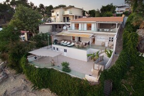 A multi-story house with a rooftop terrace, outdoor seating, and a staircase leading to the upper levels. - Infinity Beach House (Kefalonia)