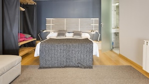 Un dormitorio con cama, mesitas de noche, armario y espejo.