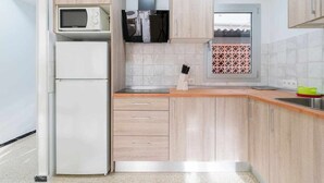 Uma cozinha moderna com micro-ondas, frigorífico e armários de madeira.