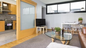 A modern living room with a glass coffee table, a sofa, and a dining area with clear chairs. - My Space Barcelona 9 Apart has 54 people with optional parking in the center (Barcelona)