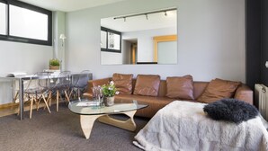 A modern living room with a glass coffee table, leather sofa, and a fur throw. - My Space Barcelona 9 Apart has 54 people with optional parking in the center (Barcelona)