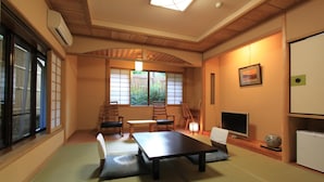 Una habitació japonesa tradicional amb paviment de tatami, una taula baixa i portes corredisses.