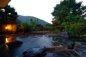 Un jardin paisible avec un étang, des rochers et des arbres.