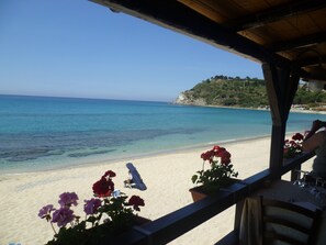 A beachside view with a clear sky, a sandy beach, and a rocky hill in the background. - APARTMENT CLOSE TO PRIVATE BEACH AND SWIMMING POOLS (Pizzo)
