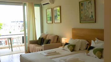 Ein Hotelzimmer mit zwei Betten, einem Balkon und einem Bild an der Wand.