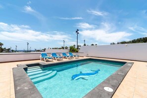 Een verwarmd zwembad en ligstoelen