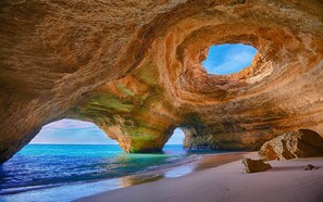 A natural rock formation with a circular opening, a beach, and the sea. - Villa Diane, Luxury Cottage, Ocean views, pool (Benagil)